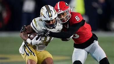 UGA defense tackling Georgia Tech running back mid-play.